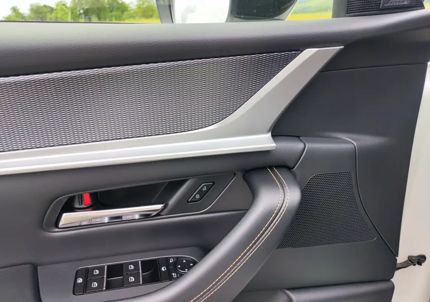 Détail de la porte côté gauche du Mazda CX-60 blanc métal 2024 avec commandes électriques et haut-parleur Bose intégré.