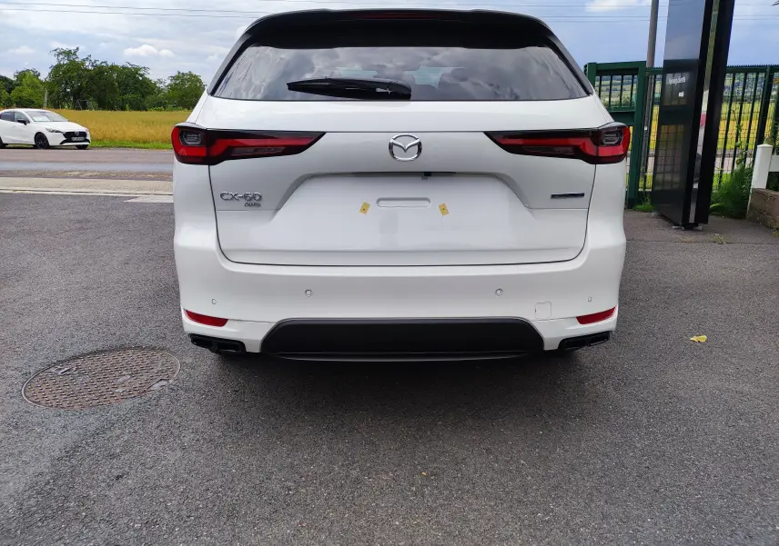 Vue arrière d'un Mazda CX-60 blanc métal 2024 avec feux LED et double sortie d'échappement noire intégrée.
