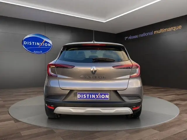 Vue arrière du Renault Captur TCE 90 Équilibre gris Cassiopée dans un showroom avec logo Distinxion en arrière-plan.