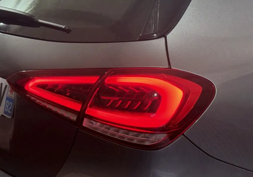 Gros plan sur le feu arrière droit rouge d’une Mercedes Classe A A 200 AMG Line gris foncé, vue arrière côté droit.