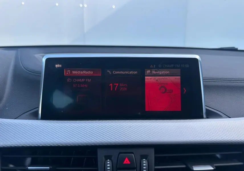 Écran central multimédia de BMW X2 gris foncé (F39) montrant radio, communication et navigation.