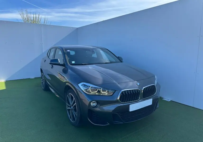 BMW X2 gris foncé vue 3/4 avant droit avec calandre double haricot et jantes alliage 19 pouces style M.
