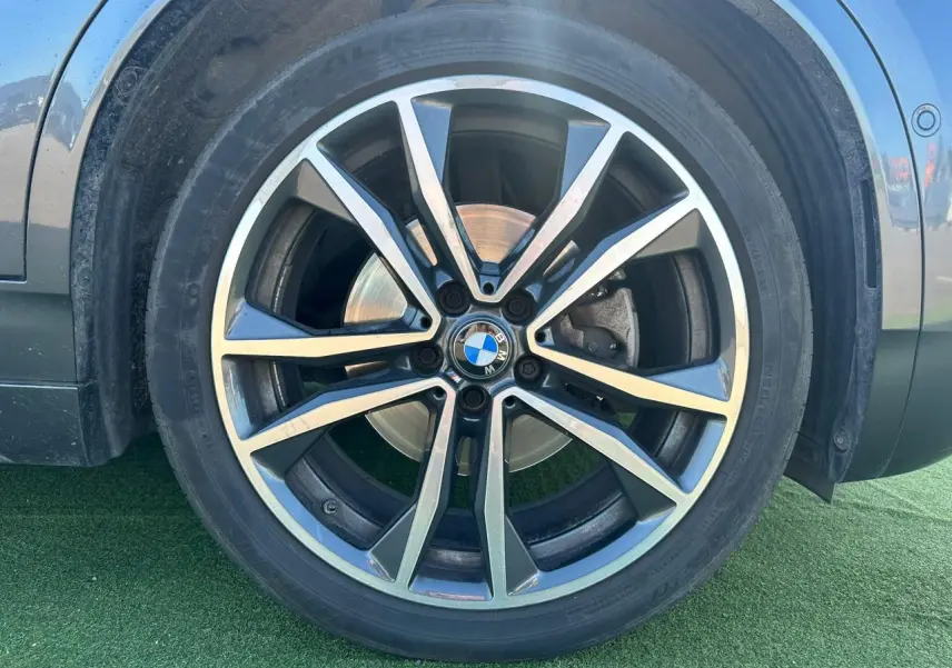 Gros plan sur la jante alliage 19 pouces style 715 M de BMW X2 gris foncé côté gauche.