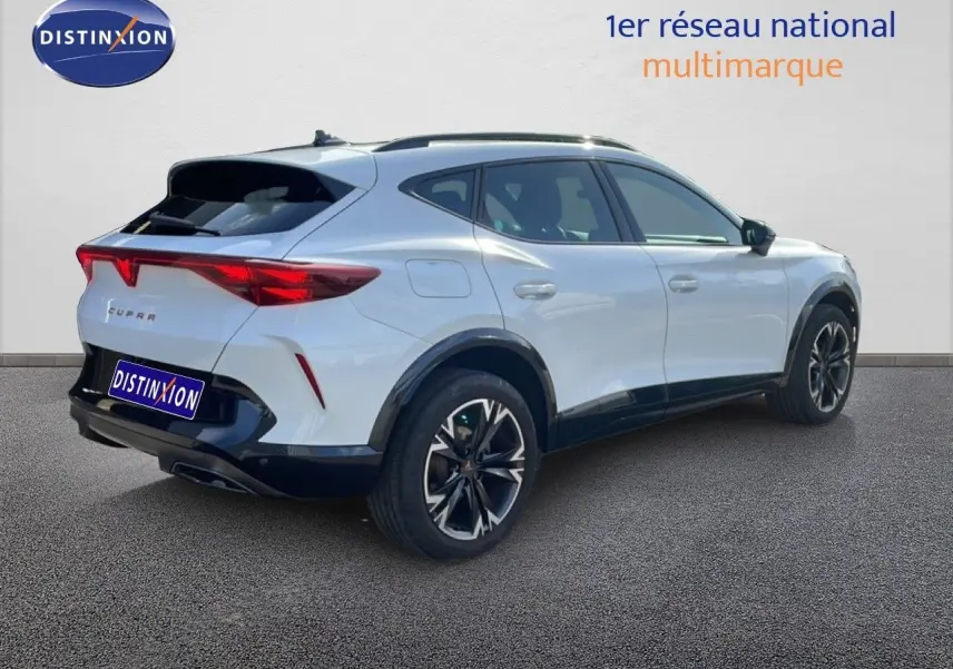 Vue 3/4 arrière droite d'un CUPRA Formentor blanc neige métal avec jantes noires et feux arrière LED distinctifs.