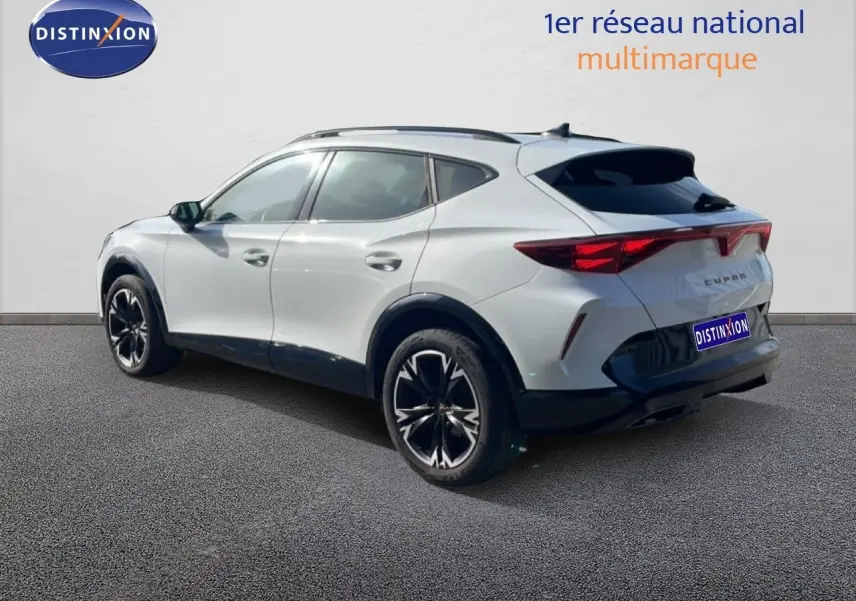 Vue 3/4 arrière droite d’un CUPRA Formentor blanc neige métal avec jantes noires et toit panoramique.