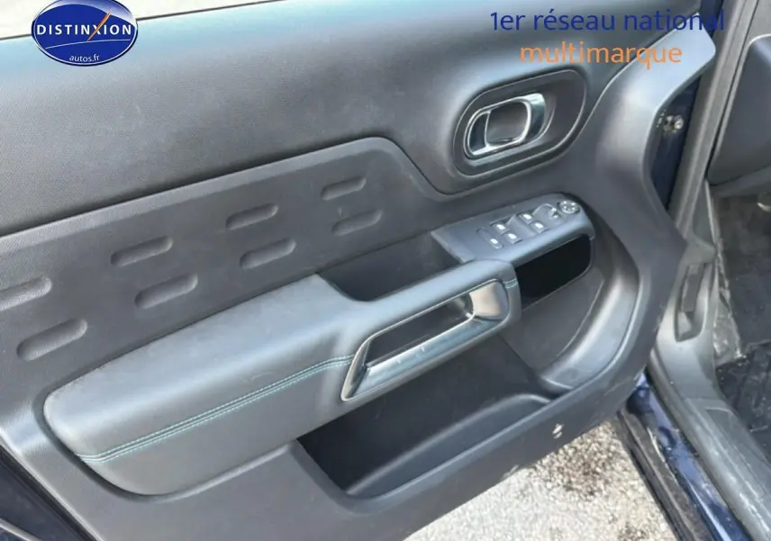 Vue rapprochée de la porte avant gauche du Citroën C5 Aircross bleu eclipse, avec commandes de vitres et poignée chrome.