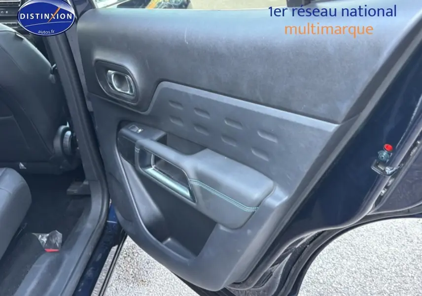 Vue intérieure du côté gauche arrière de la porte bleu eclipse du Citroën C5 Aircross avec poignée et accoudoir noir.