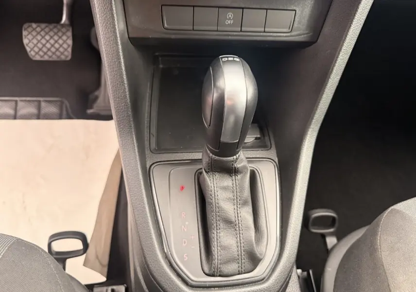 Gros plan sur le levier de vitesses DSG noir de la Volkswagen Caddy 2019, intérieur sombre avec pédale visible à gauche.