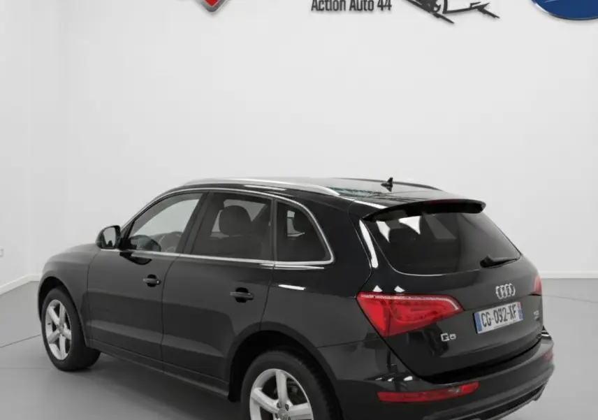 Audi Q5 noir vue 3/4 arrière droit, avec jantes alliage cinq branches et double sortie d’échappement.