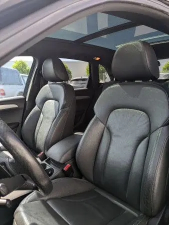 Vue intérieure de l’Audi Q5 2012 noir, montrant les sièges avant en cuir et le toit ouvrant panoramique.
