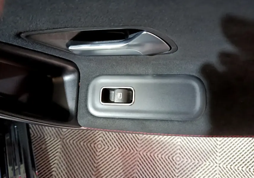 Détail de la commande de vitre électrique sur la porte intérieure noire d’une Mercedes Classe A 200 AMG Line 2021.