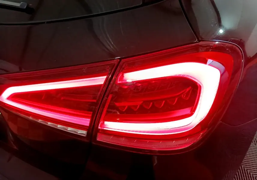 Gros plan sur le feu arrière droit allumé d’une Mercedes Classe A 200 AMG Line noire, finition brillante.