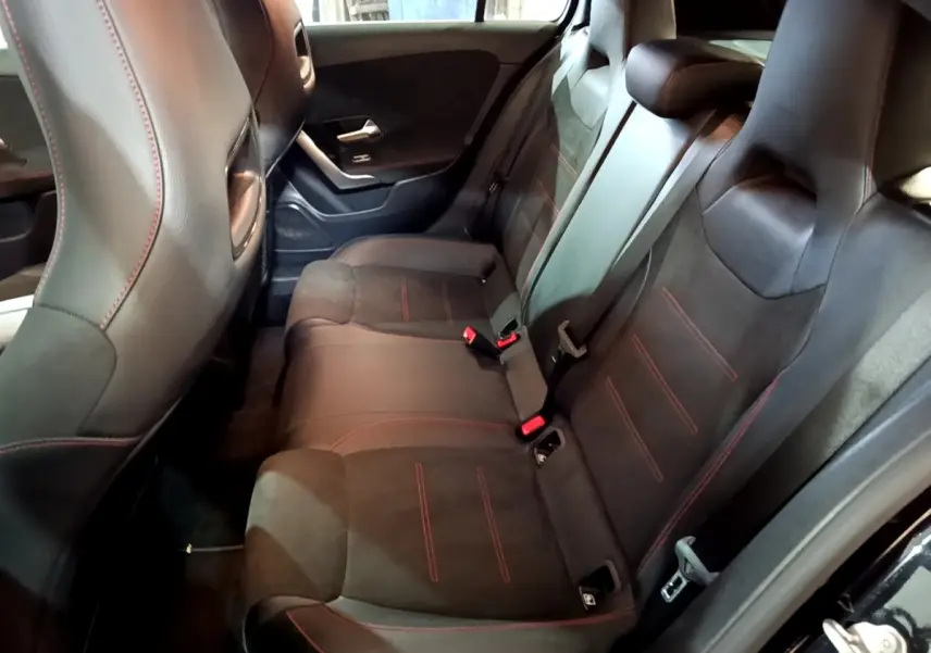 Vue intérieure côté droit des sièges arrière noirs avec surpiqûres rouges de la Mercedes Classe A A 200 AMG Line 2021.