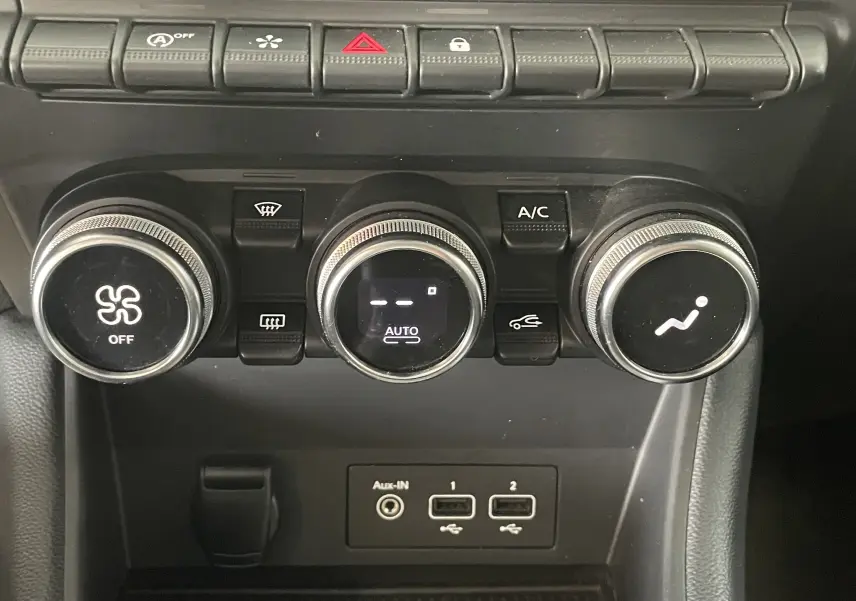 Gros plan sur les commandes de climatisation et les ports USB du tableau de bord du Renault Captur rouge 2019.