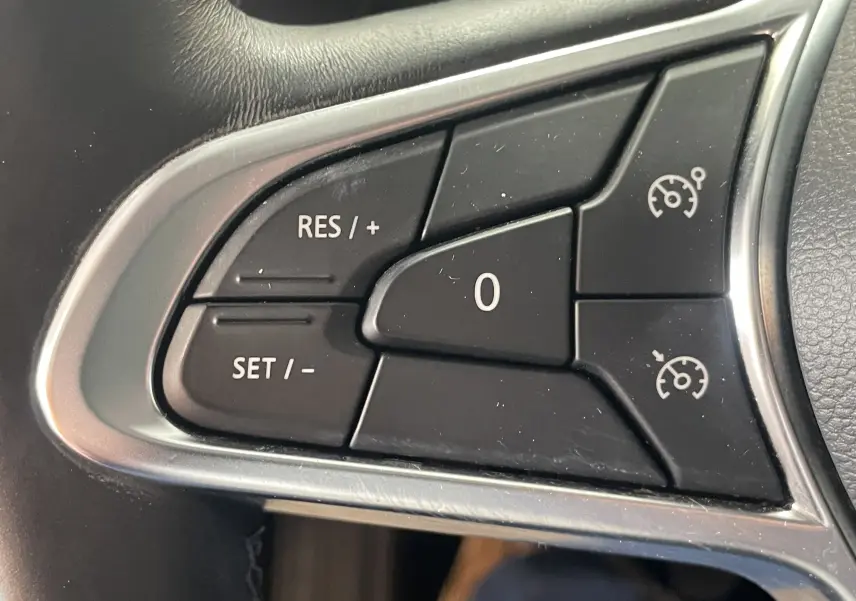 Gros plan sur les commandes de régulateur de vitesse au volant du Renault Captur rouge 2019, version Intens.