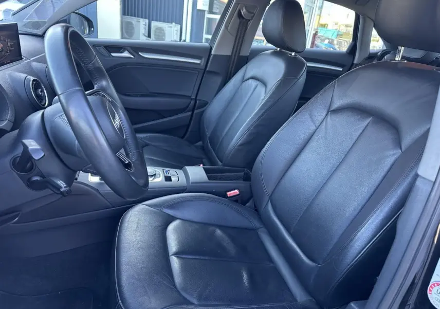 Vue intérieure côté conducteur de l'Audi A3 2020, sièges en cuir noir et volant multifonction trois branches.