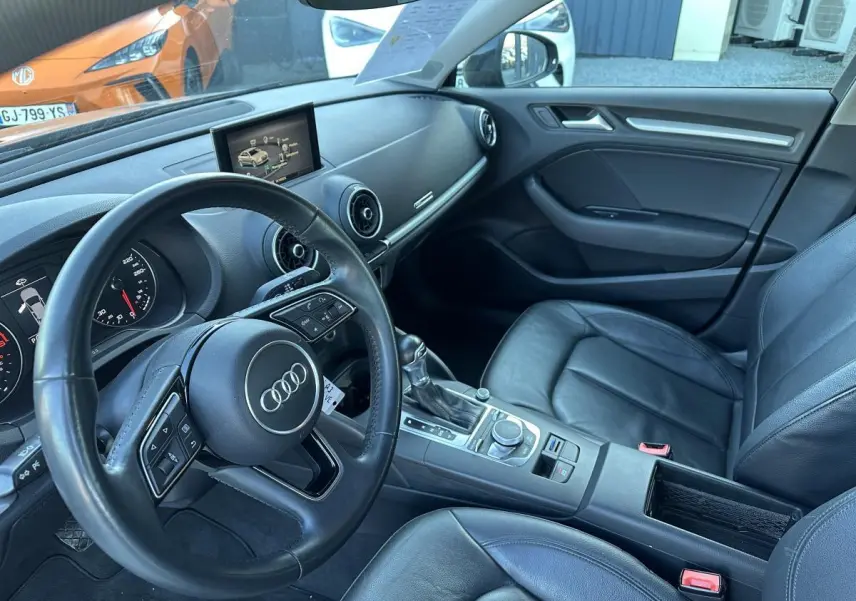 Vue intérieure côté conducteur de l'Audi A3 berline 2020 avec sellerie cuir noire et tableau de bord moderne.