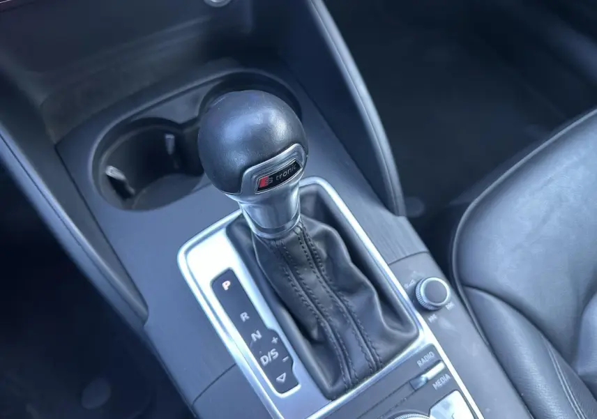 Le levier de vitesses automatique S tronic de l'Audi A3 noir, vu en gros plan depuis l'intérieur côté conducteur.