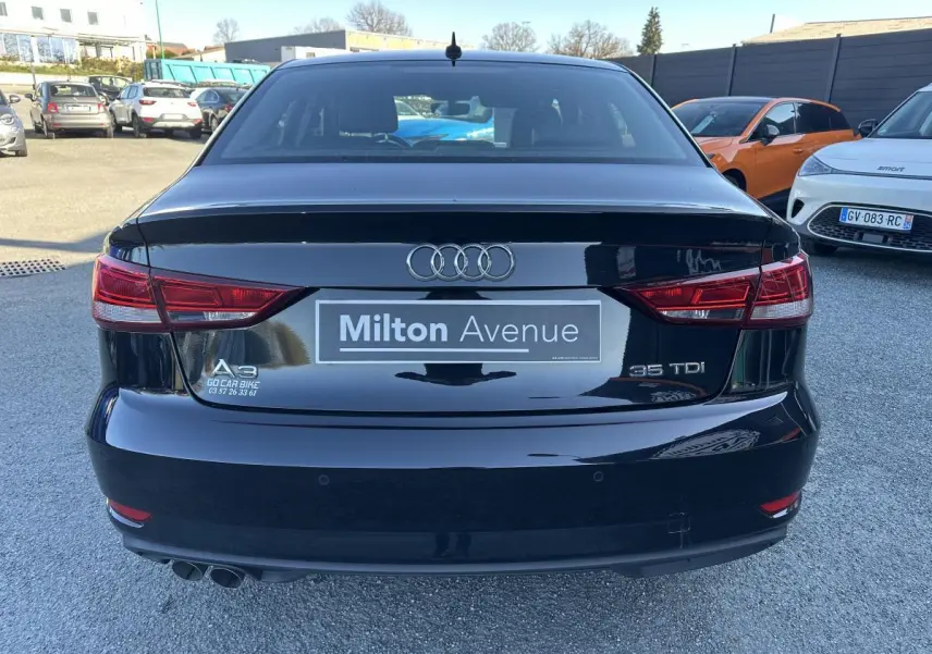 Vue arrière d'une Audi A3 berline noire 35 TDI avec feux rouges et double sortie d'échappement visible.