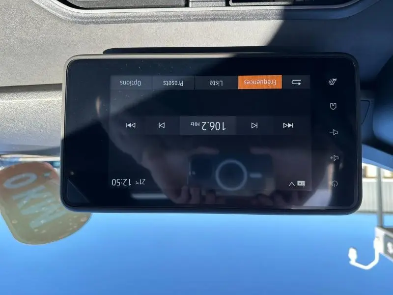 Gros plan sur l'écran tactile central du tableau de bord du Dacia Jogger 2024, affichant la radio FM à 106.2 MHz.