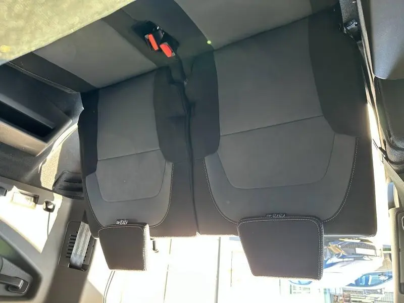 Vue plongeante sur la banquette arrière noire du Dacia Jogger 2024, montrant les appuie-têtes et ceintures de sécurité.