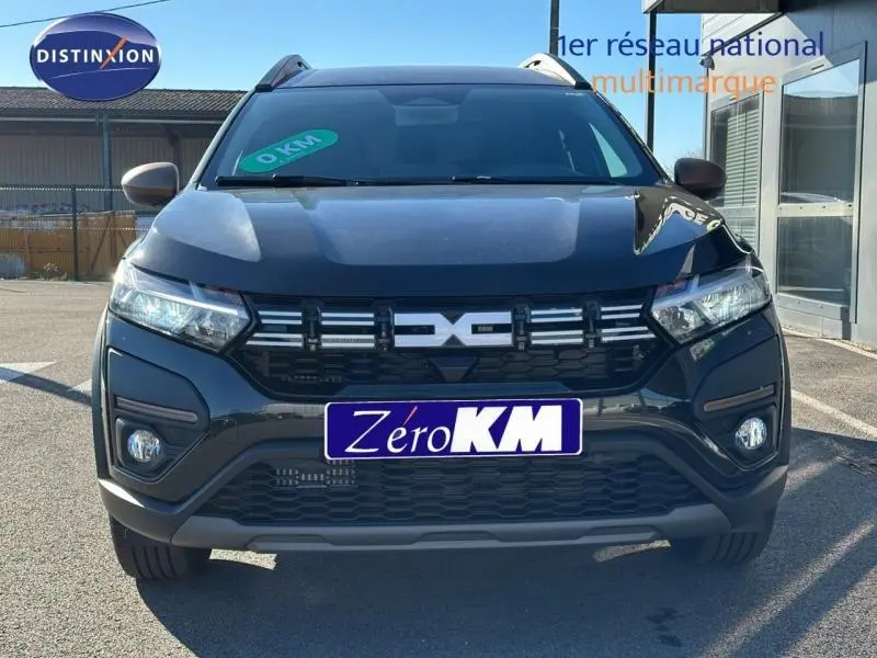 Vue avant d'un Dacia Jogger noir nacré métallisé avec calandre distinctive et phares LED allumés.