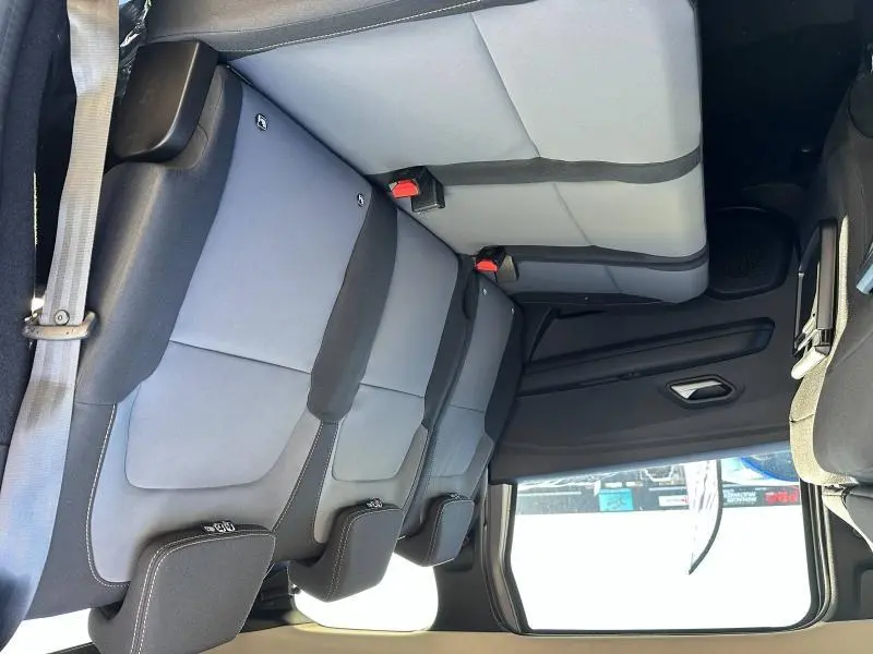 Vue latérale intérieure montrant la banquette arrière grise et noire du Dacia Jogger 2024 avec appuie-têtes et ceintures visibles.