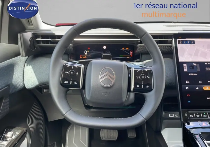 Vue centrée sur le volant cuir du Citroën C5 Aircross Hybrid rouge rubis, avec tableau de bord numérique et écran tactile visible.