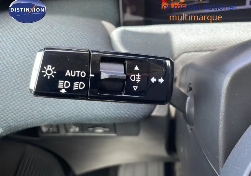 Gros plan sur la commande des feux et clignotants du Citroën C5 Aircross Hybrid rouge rubis, intérieur tissu gris.