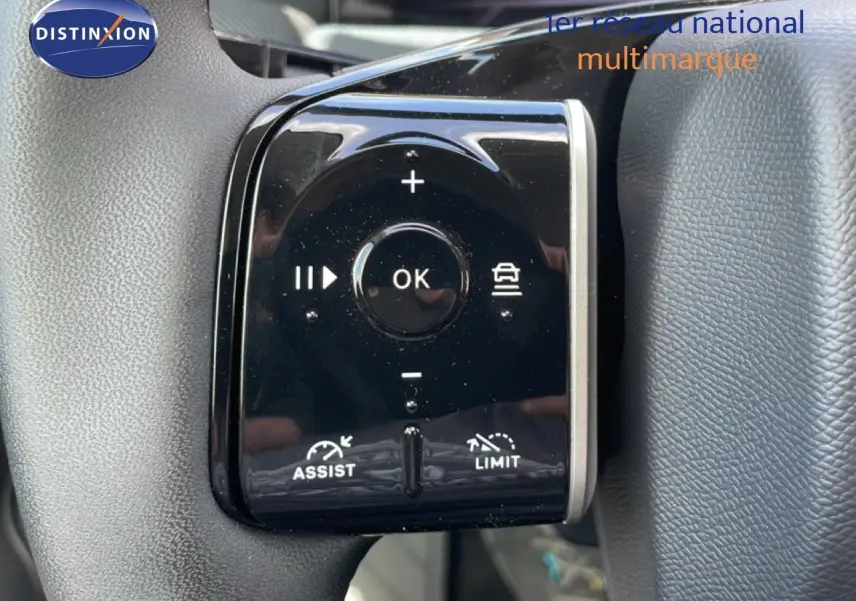 Gros plan sur les commandes noires du volant du Citroën C5 Aircross Hybrid rouge rubis, avec boutons d'assistance et limitation.