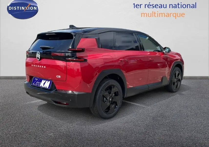 Vue 3/4 arrière droite d'un Citroën C5 Aircross Hybrid rouge rubis métallisé avec toit noir et jantes noires.