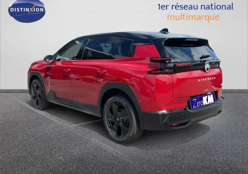 Vue 3/4 arrière droite d'un Citroën C5 Aircross rouge rubis métallisé avec toit noir et jantes noires.