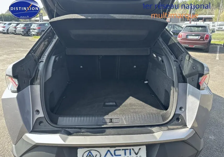 Coffre ouvert d’un Peugeot 3008 gris artense me vu de l’arrière, montrant un espace de chargement spacieux et propre.