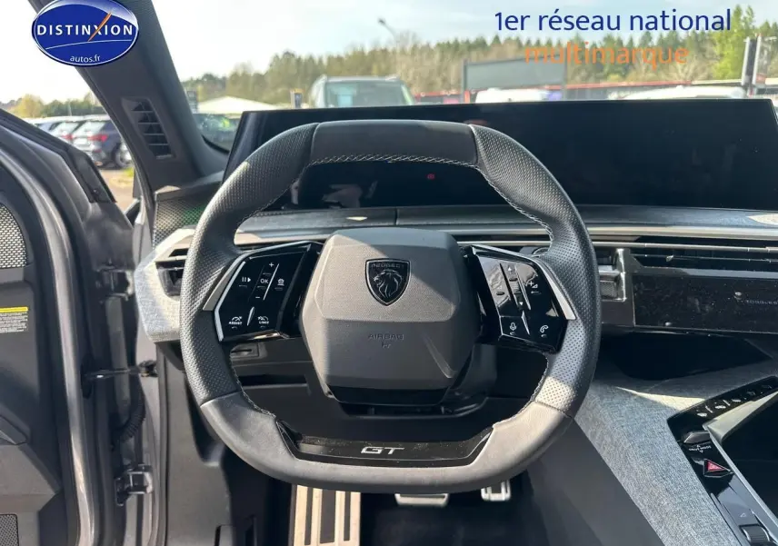 Vue intérieure centrée sur le volant cuir GT de la Peugeot 3008 gris Artense avec tableau de bord moderne.