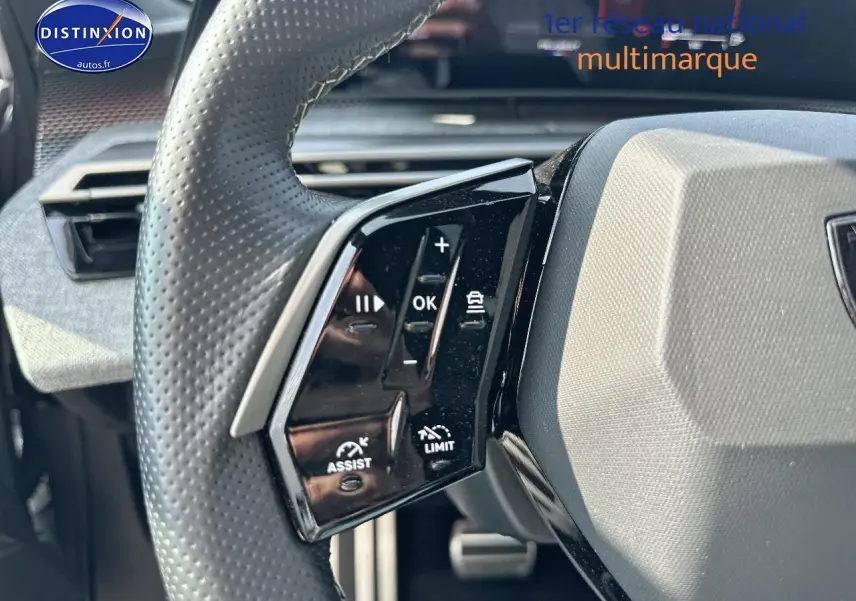 Gros plan sur le volant cuir perforé côté gauche du Peugeot 3008 gris Artense, avec commandes multifonctions visibles.