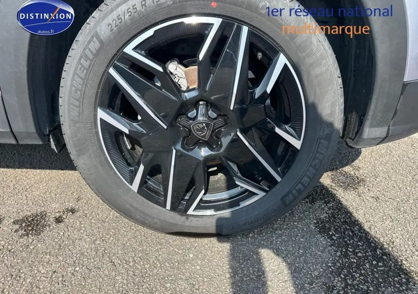 Gros plan sur la jante alu noire et argentée du côté avant droit d’un Peugeot 3008 gris Artense.
