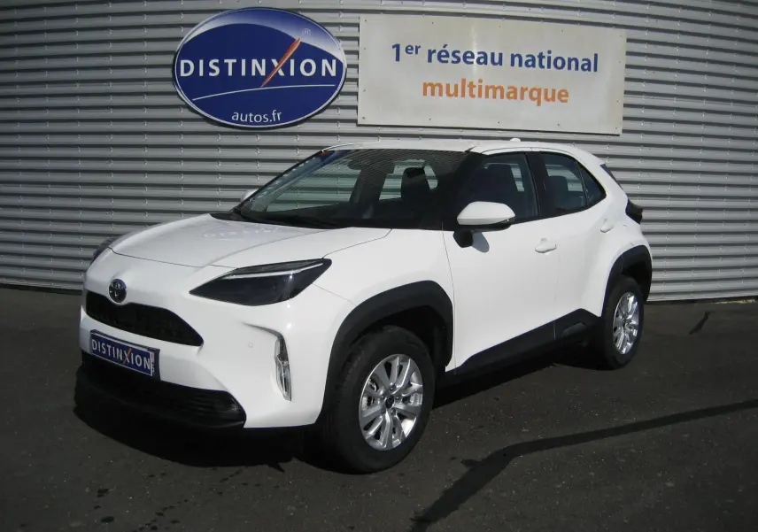 Toyota Yaris Cross blanc vue 3/4 avant droit, avec protections noires sur les passages de roues et jantes argentées.