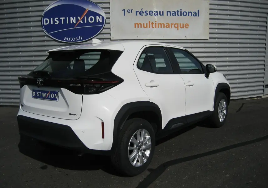 Toyota Yaris Cross blanc en vue 3/4 arrière droit, avec détails noirs contrastants et jantes alliage argentées.