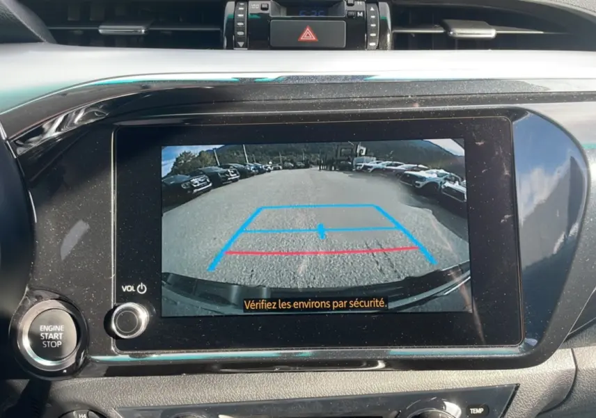 Vue intérieure du tableau de bord du Toyota Hilux 2025 avec écran de caméra de recul affichant l'arrière du véhicule.