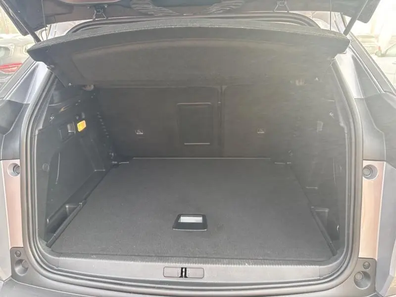 Coffre ouvert en vue arrière du Peugeot 3008 gris Artense, montrant un espace de chargement vide et propre.