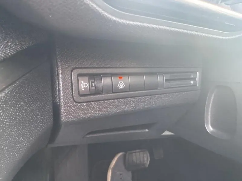 Détail du tableau de bord noir du Peugeot 3008 2022 montrant les commandes d'éclairage et d'aide à la conduite côté gauche.