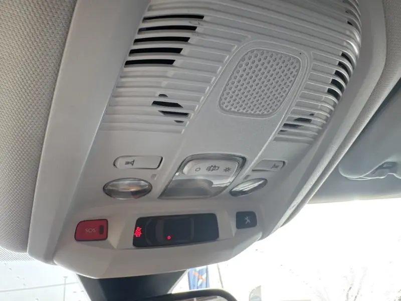Plafonnier intérieur avec commandes d'éclairage et bouton SOS du Peugeot 3008 gris Artense, vue depuis l'avant conducteur.