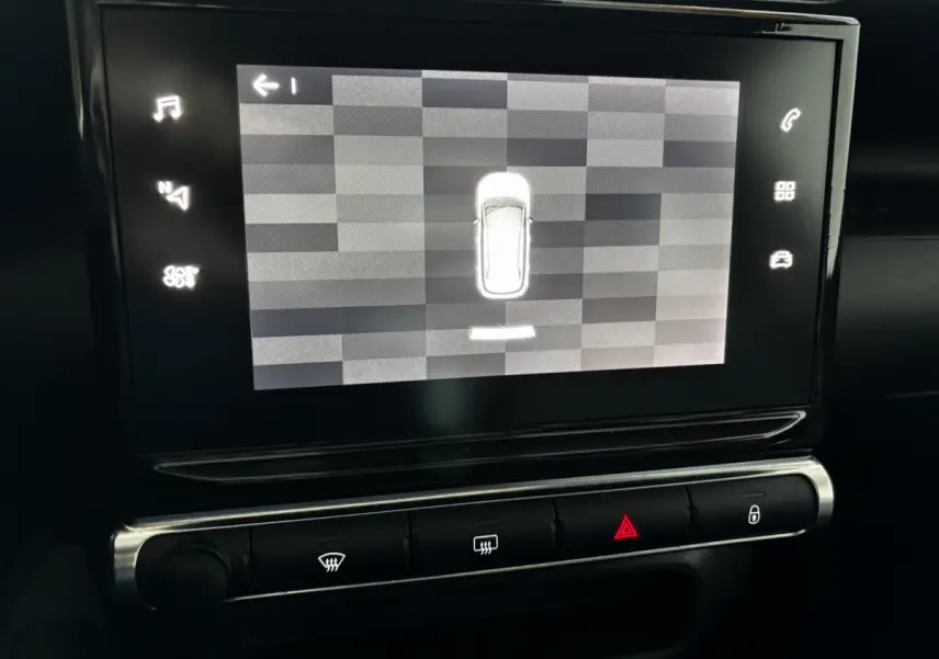 Écran tactile central du tableau de bord du Citroën C3 Aircross blanc, affichant l'aide au stationnement en vue aérienne.