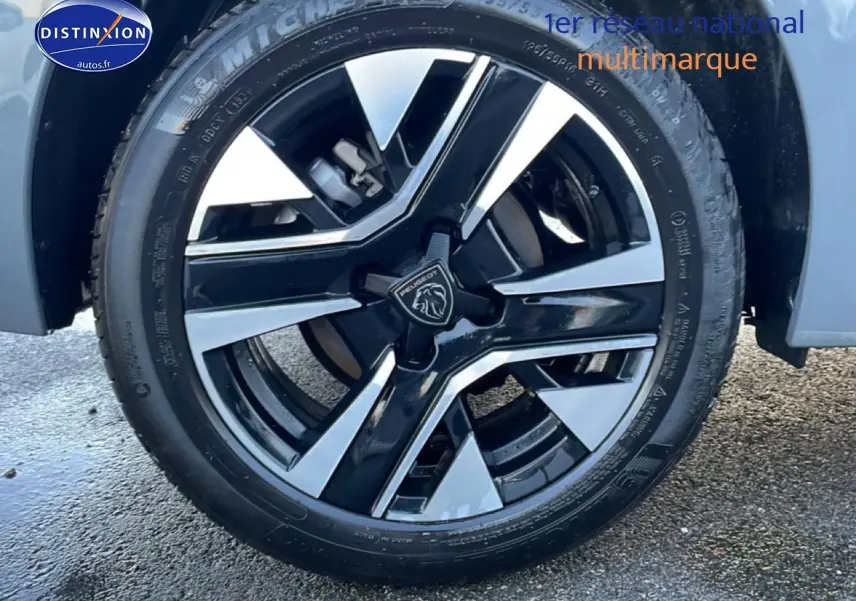 Gros plan sur la jante alu noire et argentée d'une Peugeot 208 gris sélénite, vue côté droit avant.