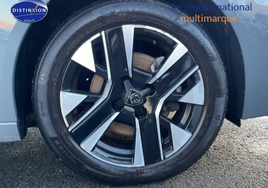 Gros plan sur la jante alu bicolore noire et argentée de la Peugeot 208 gris sélénite, côté avant droit.