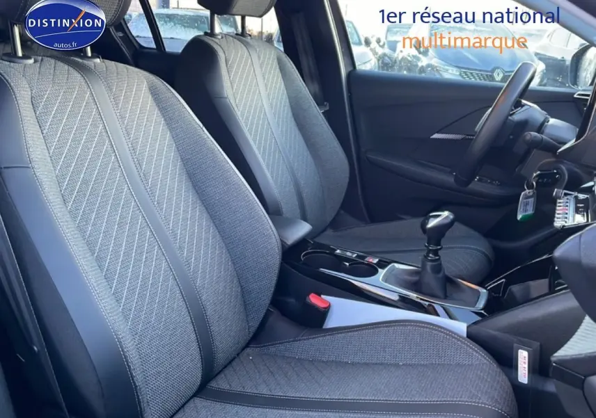 Vue intérieure côté gauche des sièges avant gris tissu et cuir de la Peugeot 208 1.2 100 allure avec boîte manuelle.