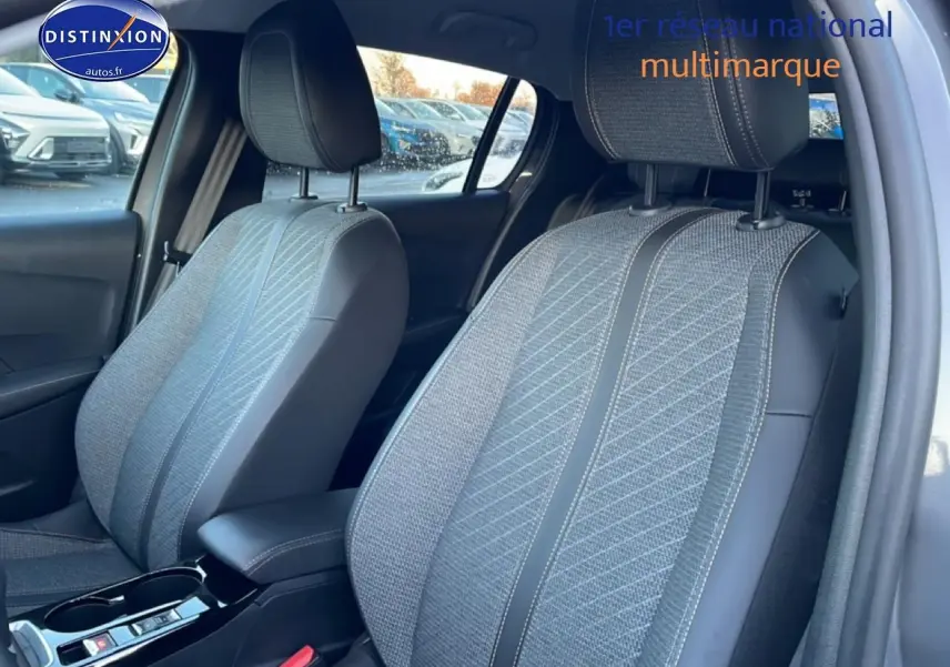 Vue intérieure rapprochée des sièges avant en tissu gris de la Peugeot 208 1.2 100 Allure 2025.