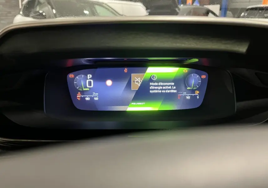 Combiné numérique 10 pouces de la Peugeot 308 GT 2024 affichant le mode économie d'énergie en vert.