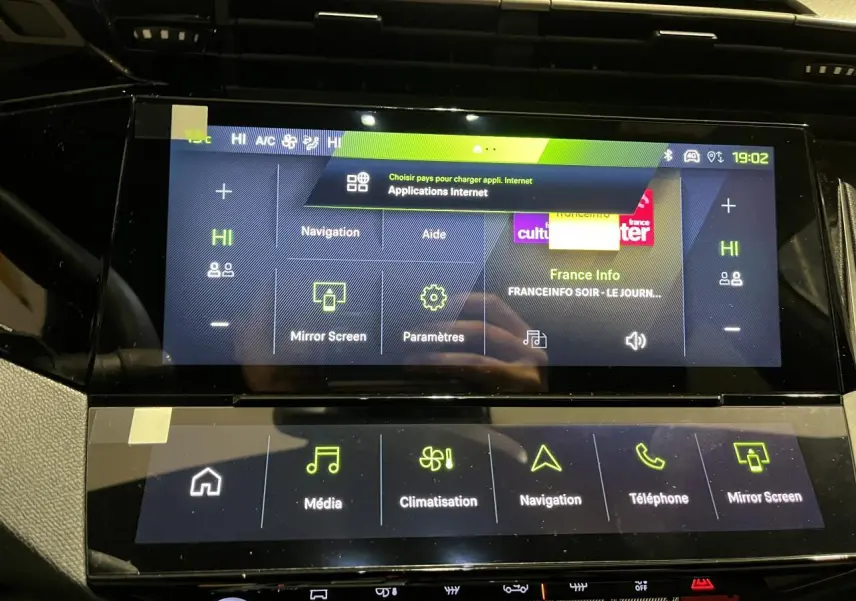 Gros plan sur l’écran tactile central de la Peugeot 308 GT 2024 gris Artense, affichant les menus multimédia et navigation.