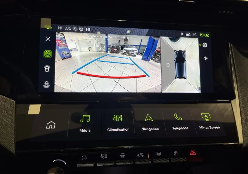 Écran multimédia montrant la caméra de recul et vue 360° d’une Peugeot 308 gris Artense en intérieur.